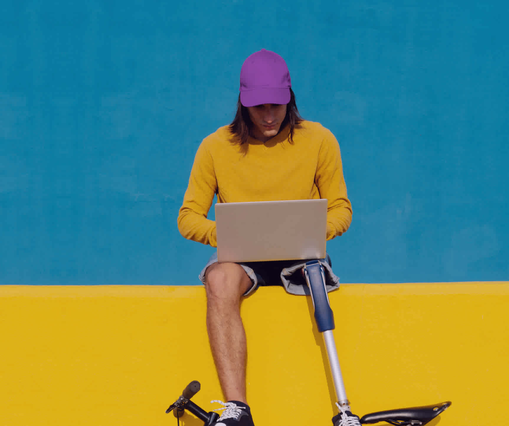 A man with a prosthetic leg working on a laptop