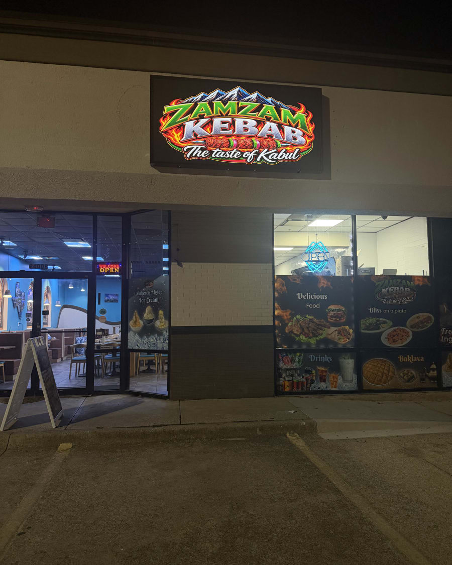 The lit Zamzam Kebab sign over the storefront at night