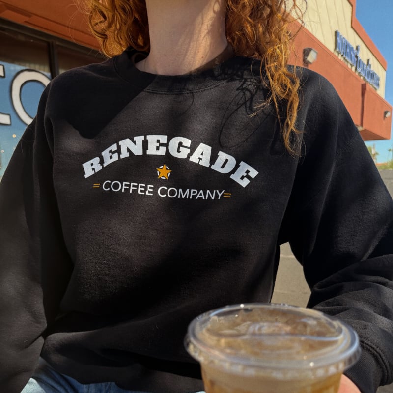 A guest in a black Renegade Coffee Company pullover sweatshirt holding an iced coffee