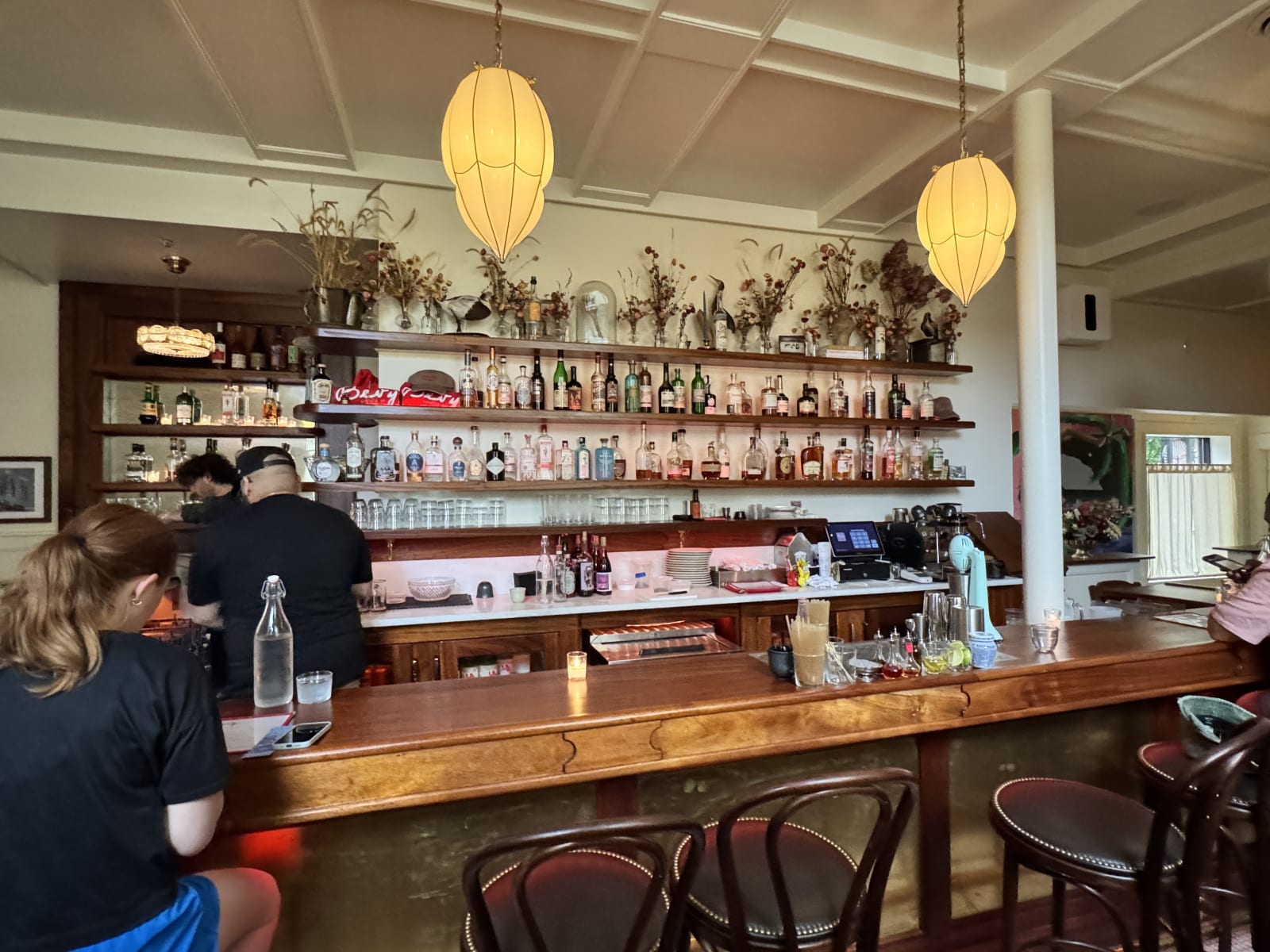 Guests sitting along the bar at Bevy in the late afternoon