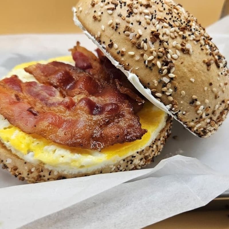 Bacon, egg and cheese on an everything bagel in deli paper