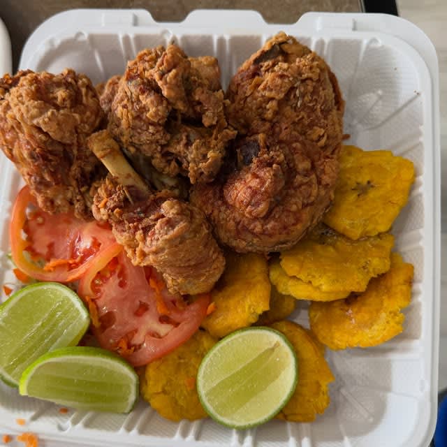 Fried chicken with tostones, tomato and lime