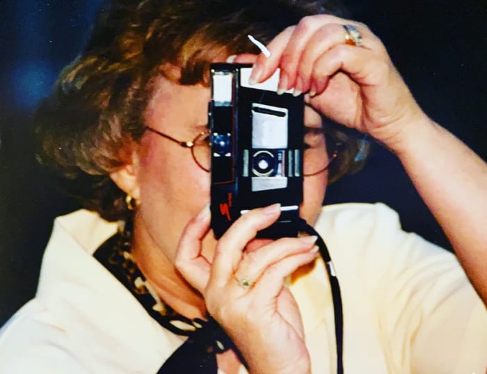 A guest snapping a photo with a camera at The Pizza Kitchen