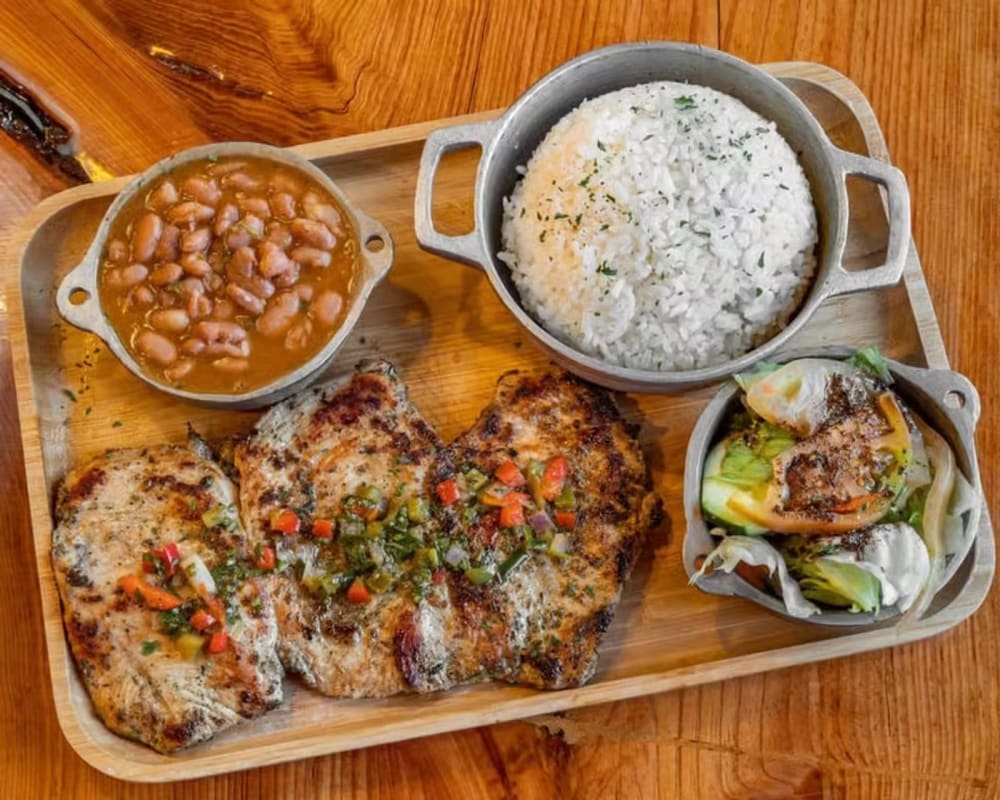 Grilled pork chops with rice, stewed beans and salad