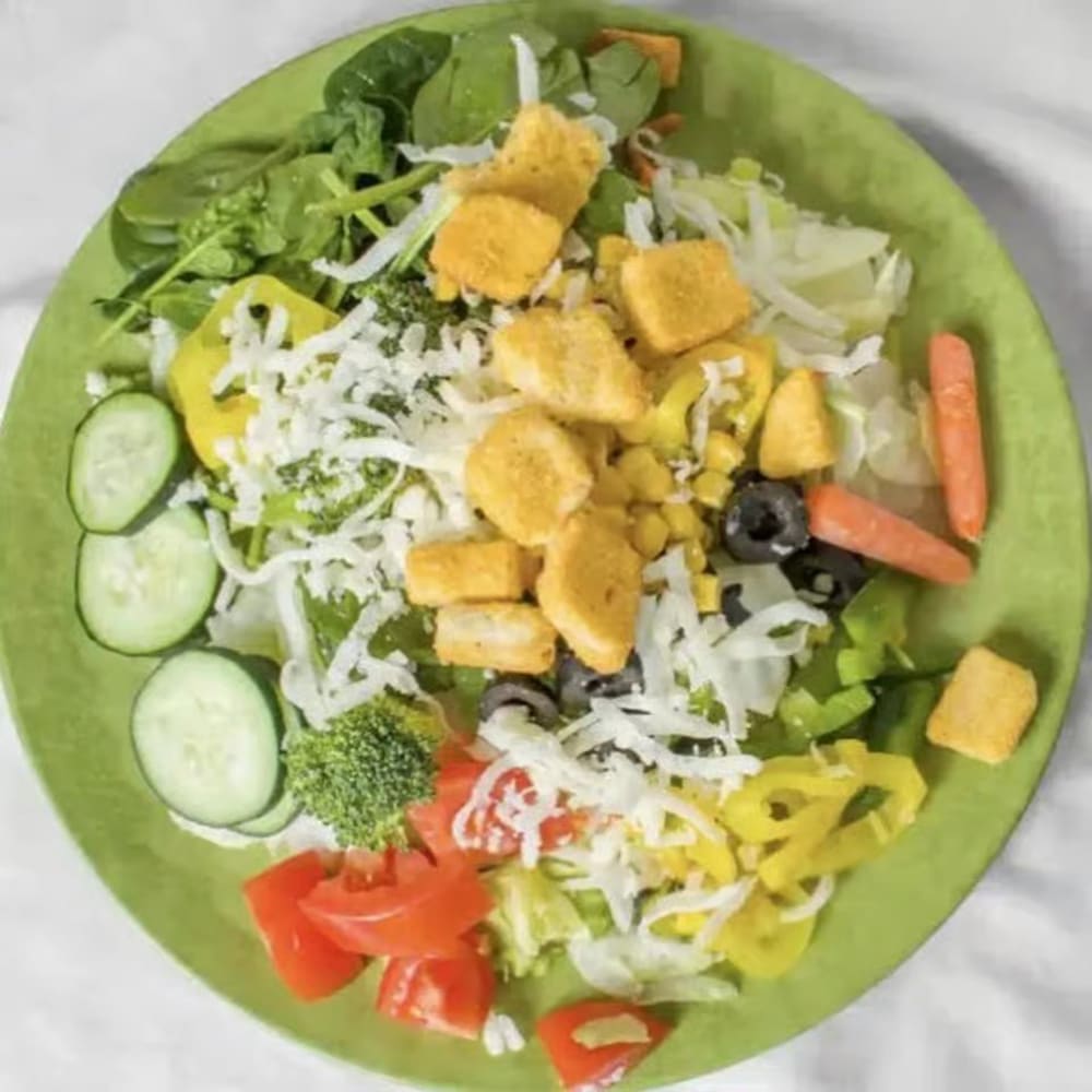 Large salad with mixed greens, cucumbers, tomatoes, croutons, peppers and shredded cheese