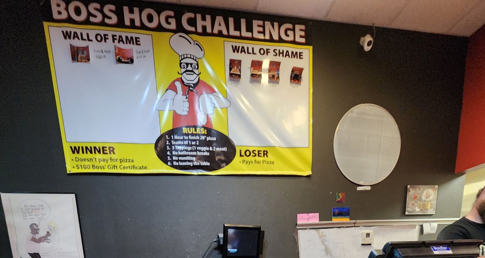 The Boss Hog Challenge banner with its Wall of Fame and Wall of Shame inside the restaurant