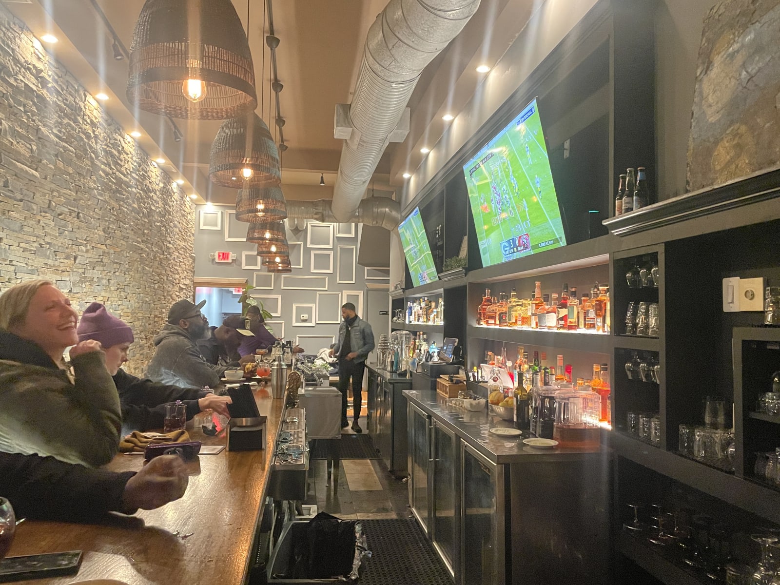 The lit back bar with guests seated along it