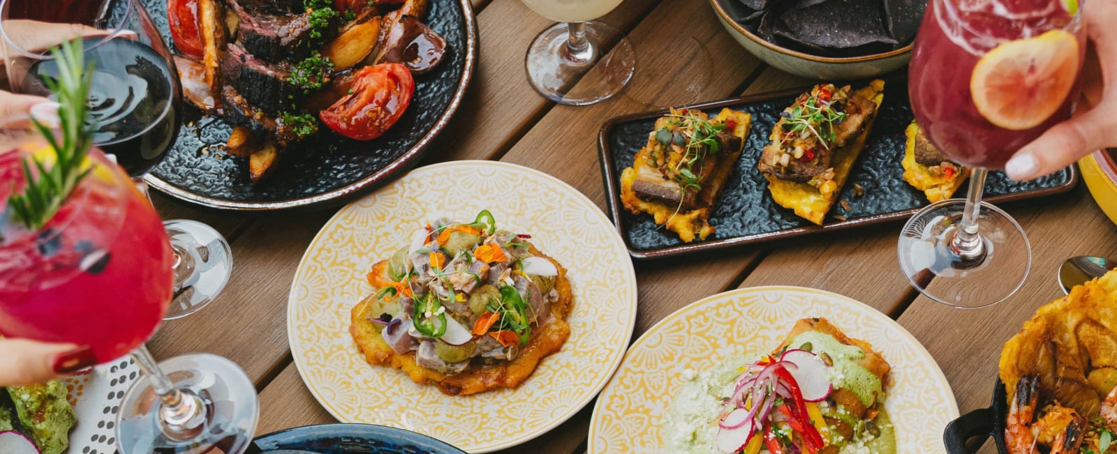 Ceviche, tostones and cocktails on a wood table at Cuya on Glenwood South