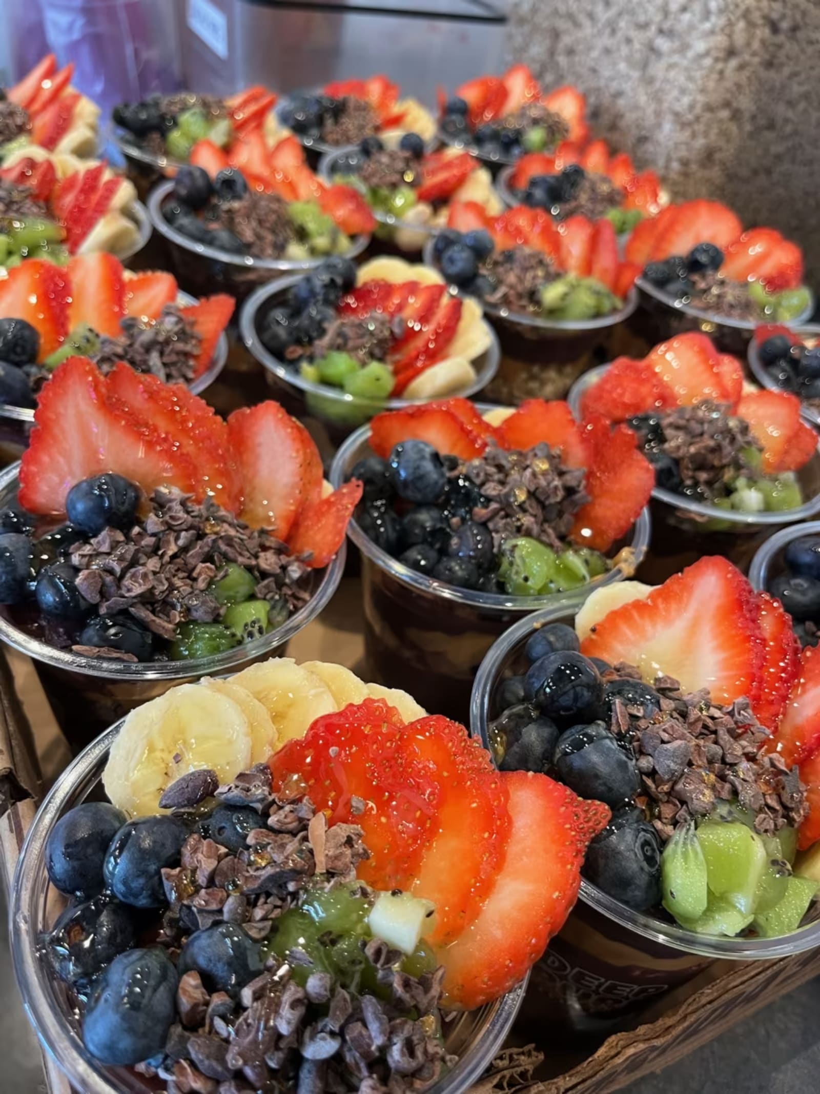 Close up of a Deep Purpl açaí bowl topped with strawberries, blueberries and kiwi