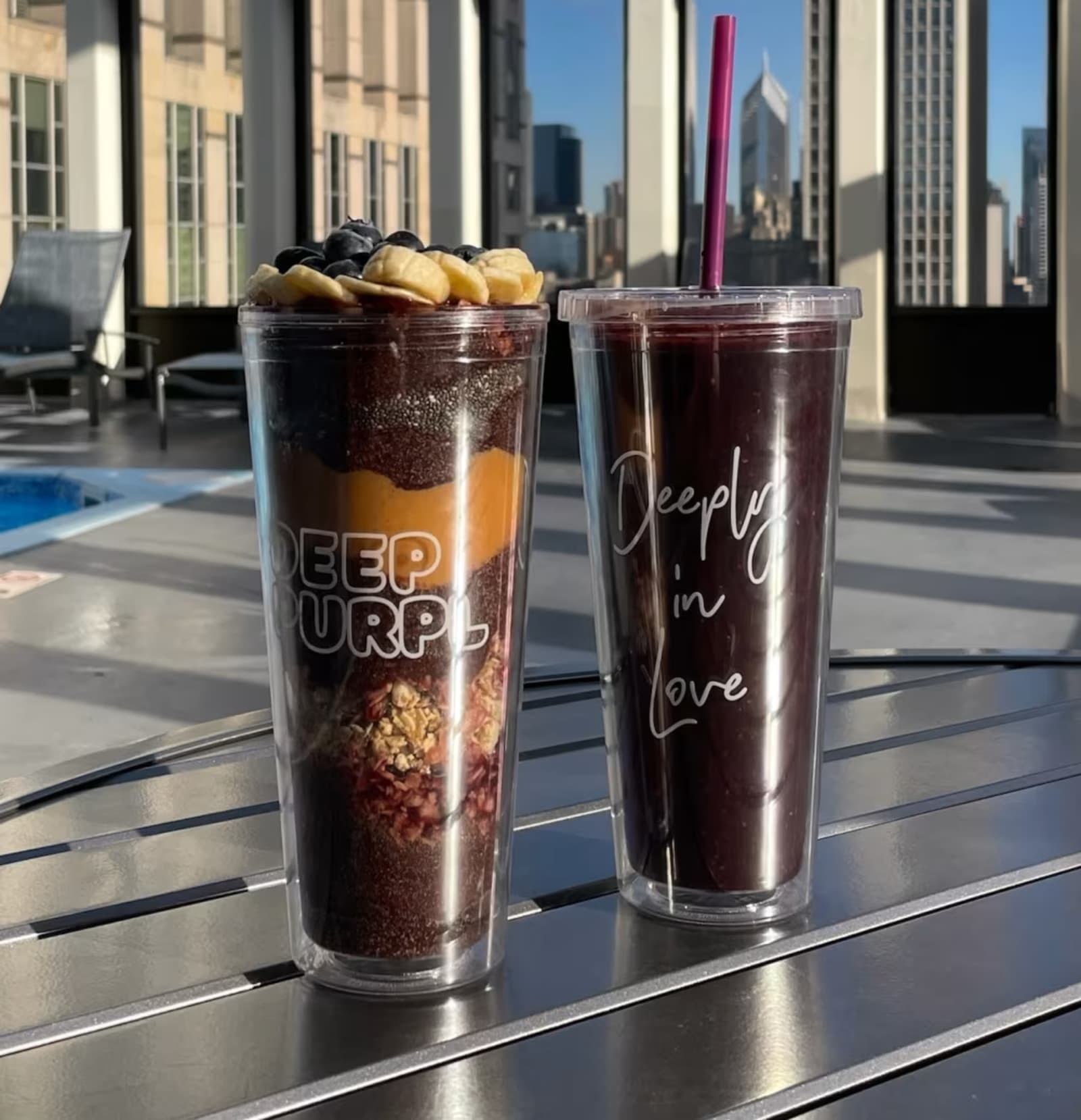 Two Deep Purpl cups on a rooftop table with the Chicago skyline behind