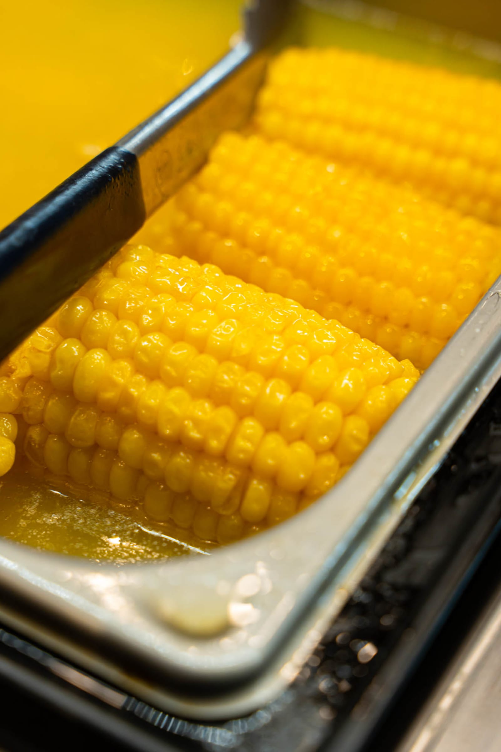 Corn on the cob halves in a serving pan
