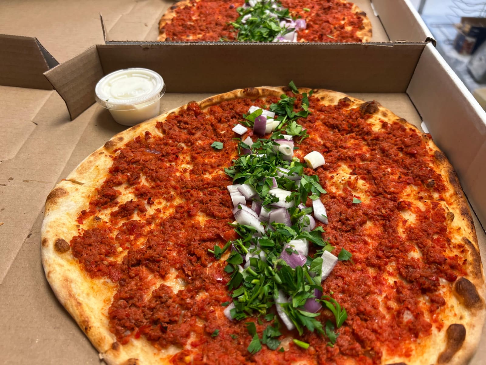 A lahmacun fresh from the oven, herbs down the middle