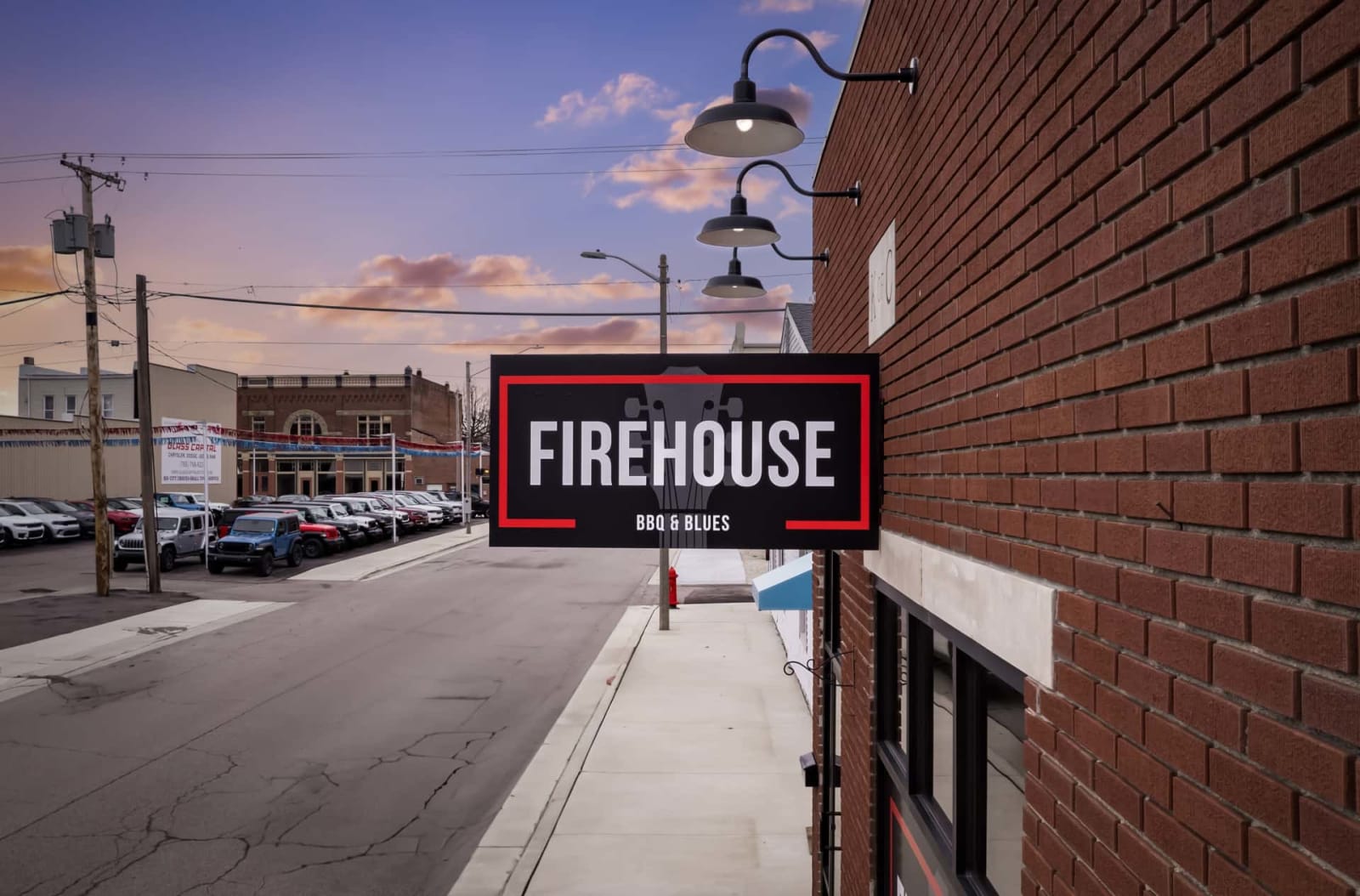 The Firehouse BBQ & Blues sign on Commerce Street in Dunkirk at dusk