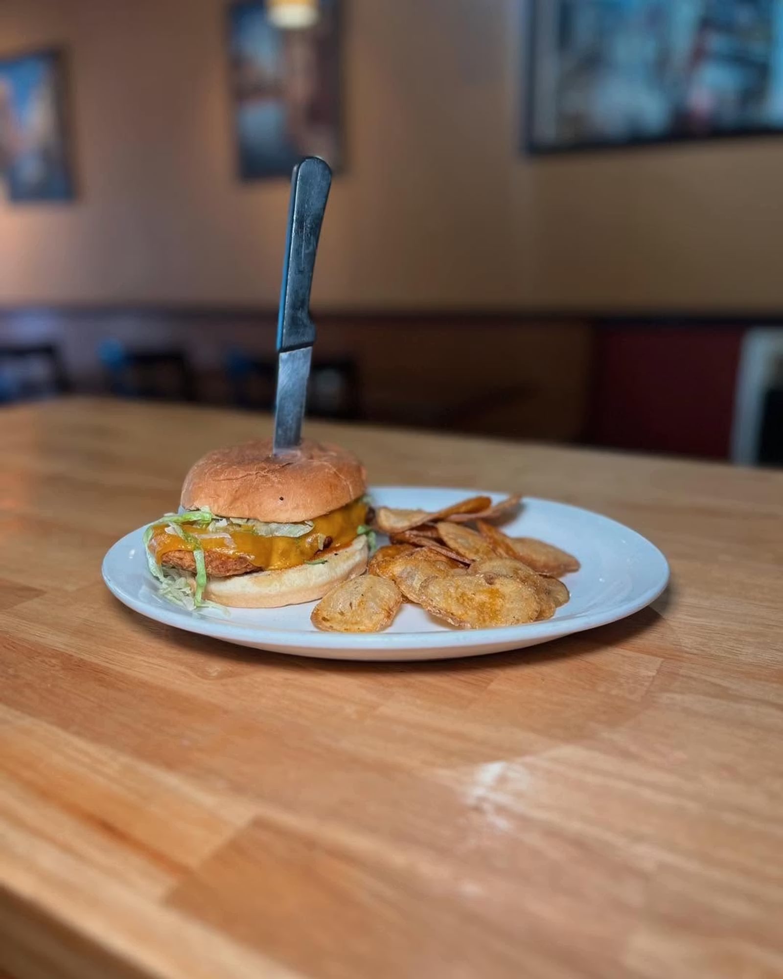 A crispy chicken sandwich and potato chips on the table