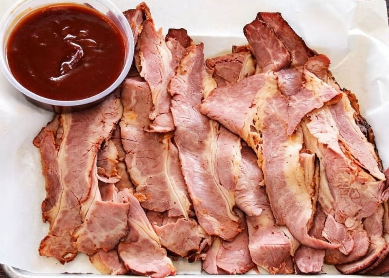 Sliced smoked pastrami fanned on paper