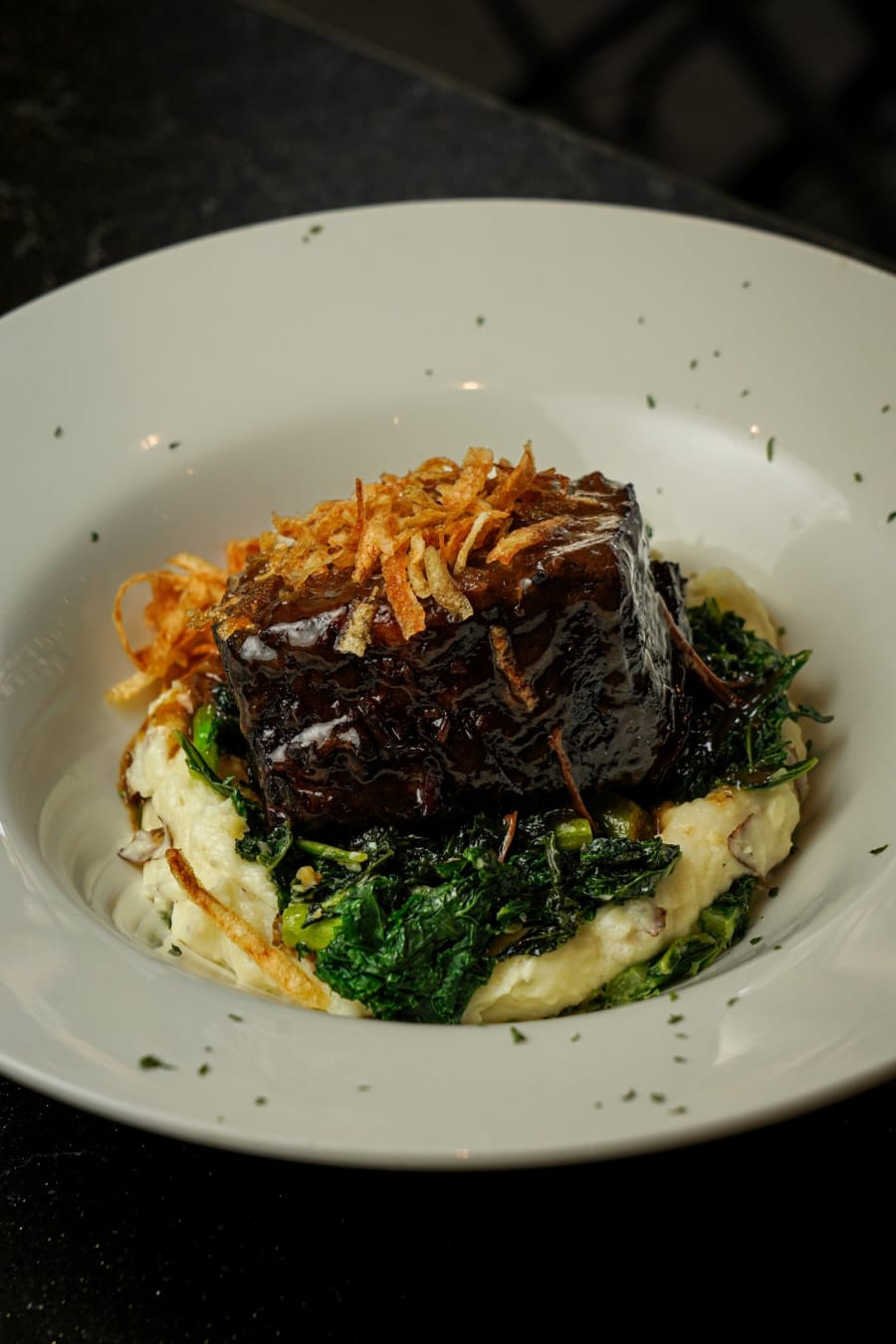 Braised short rib over mashed potatoes and greens