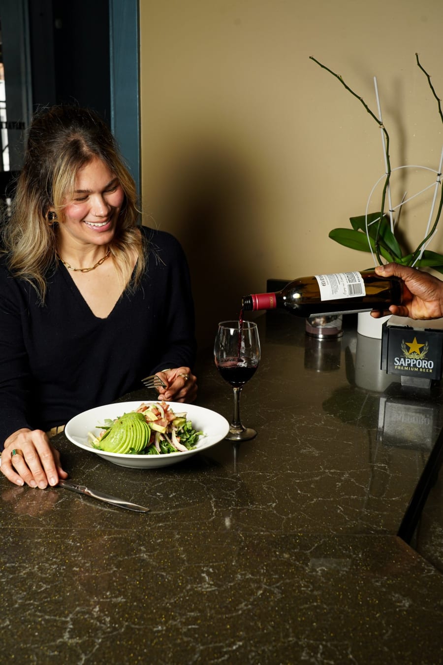 A guest dining at Chocolat as wine is poured