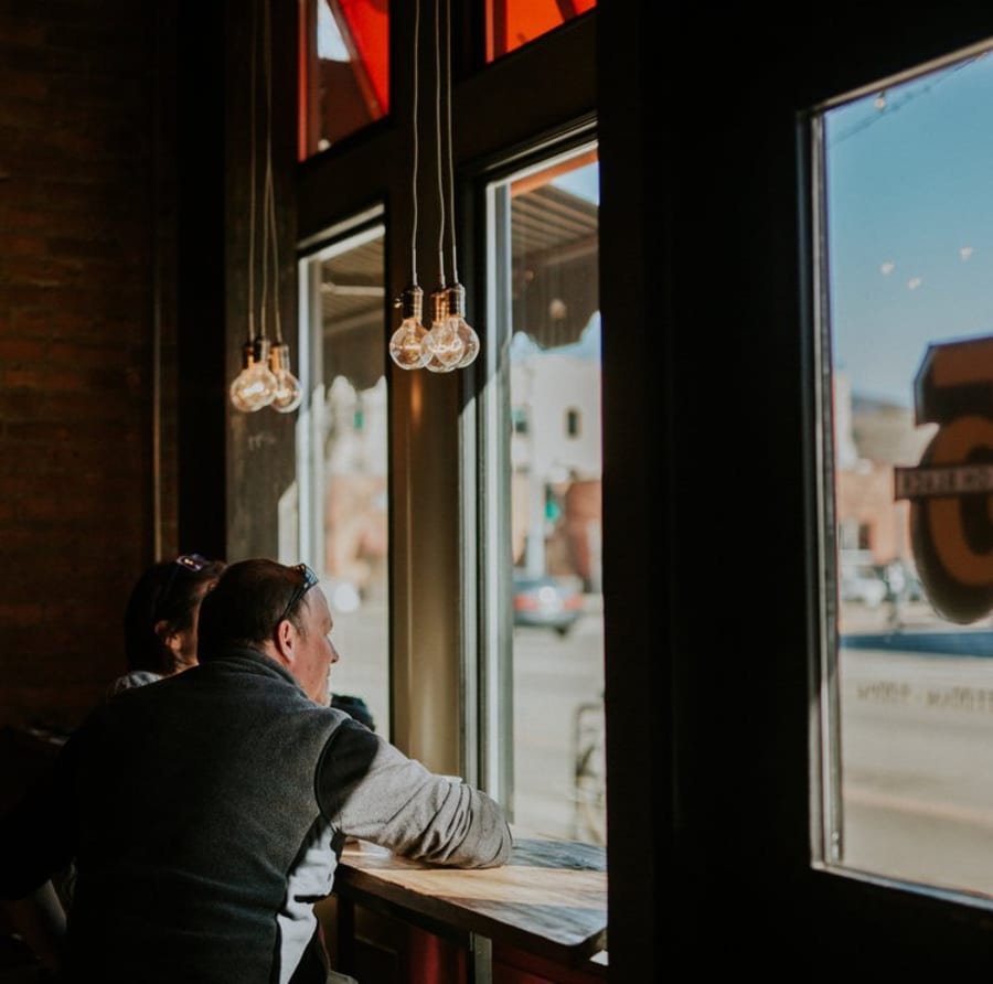 Warm pendant lighting over the window bar inside Five on Black