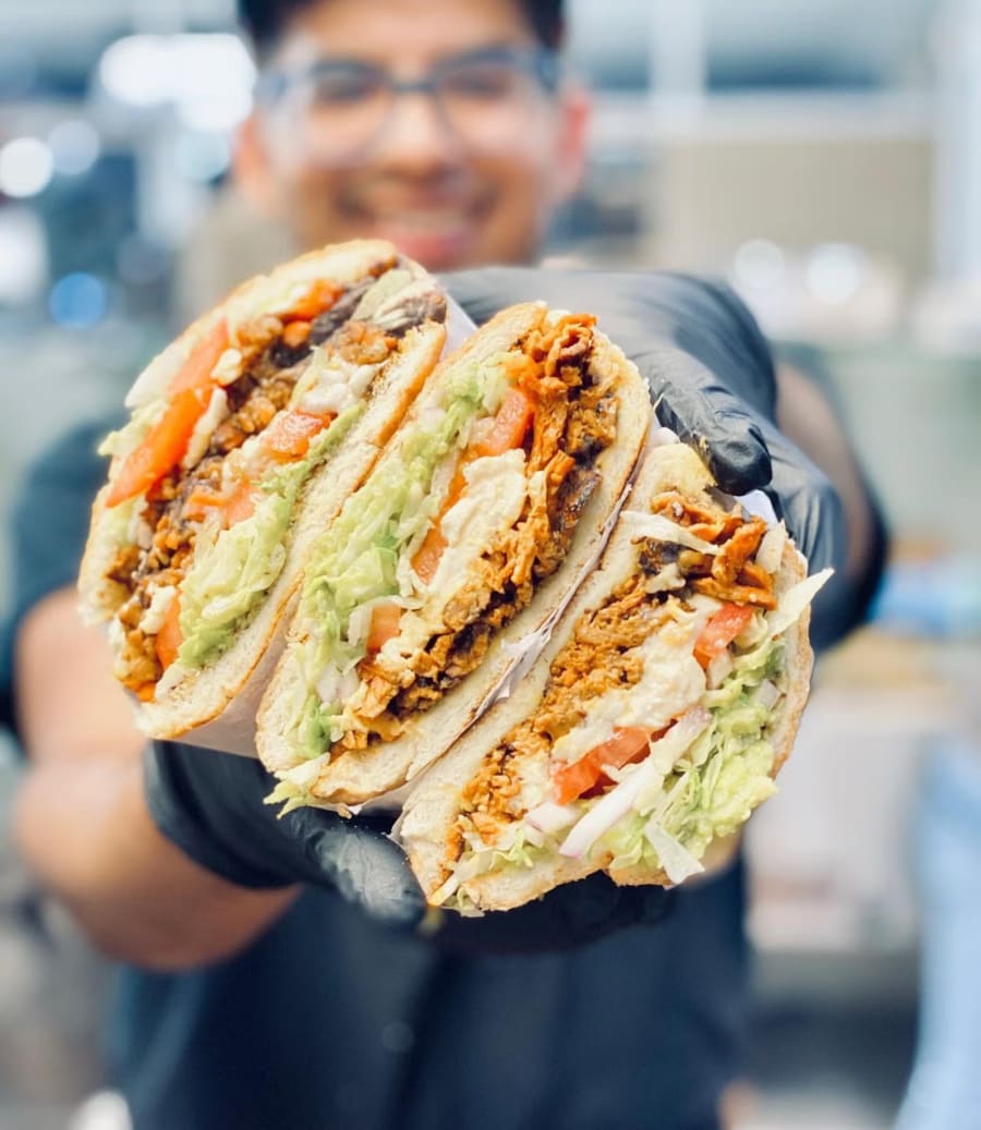 A Nuno's cook holding a krunchwrap cut in half