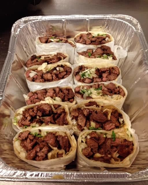 A catering tray of steak burritos ready for pickup