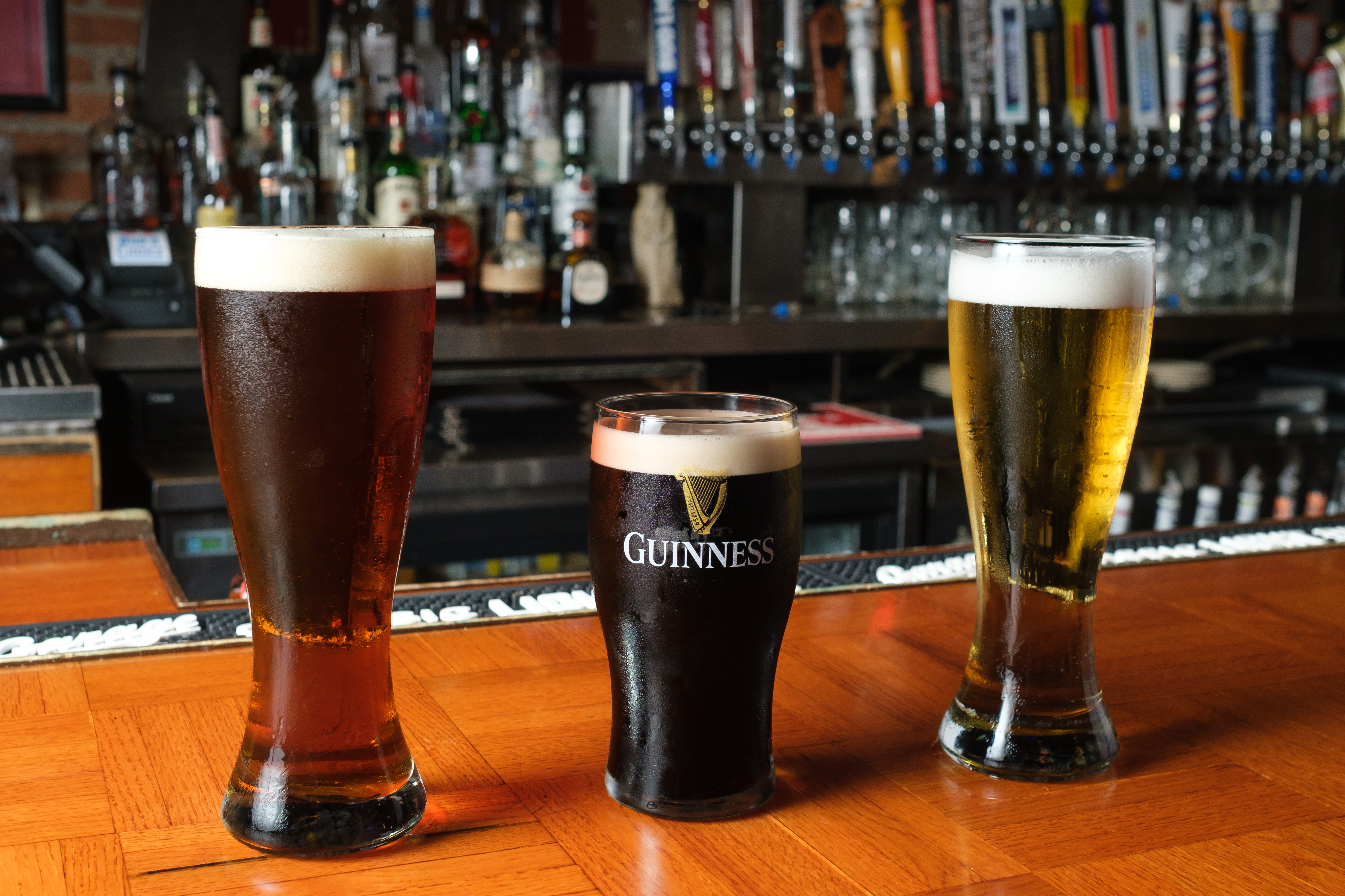 Pints of draft beer lined up on the bar