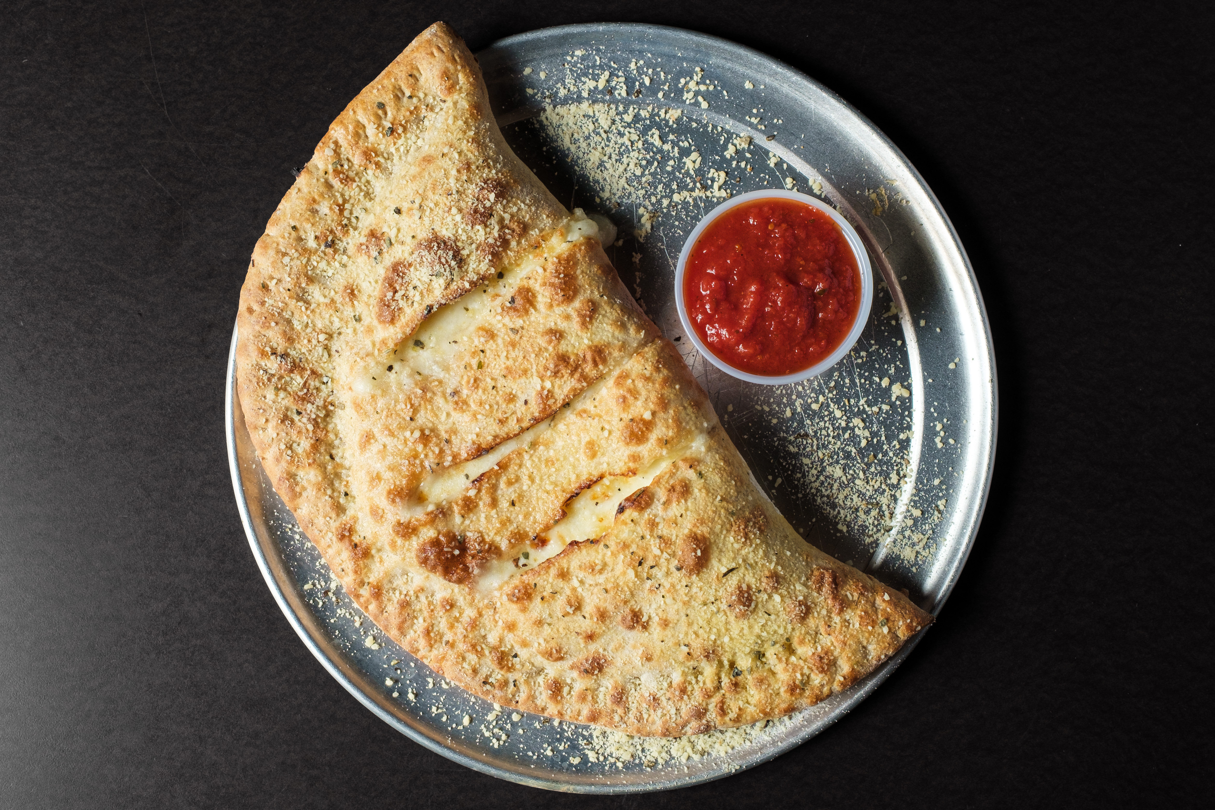 Calzone cut open to show sausage, pepperoni and melted cheese