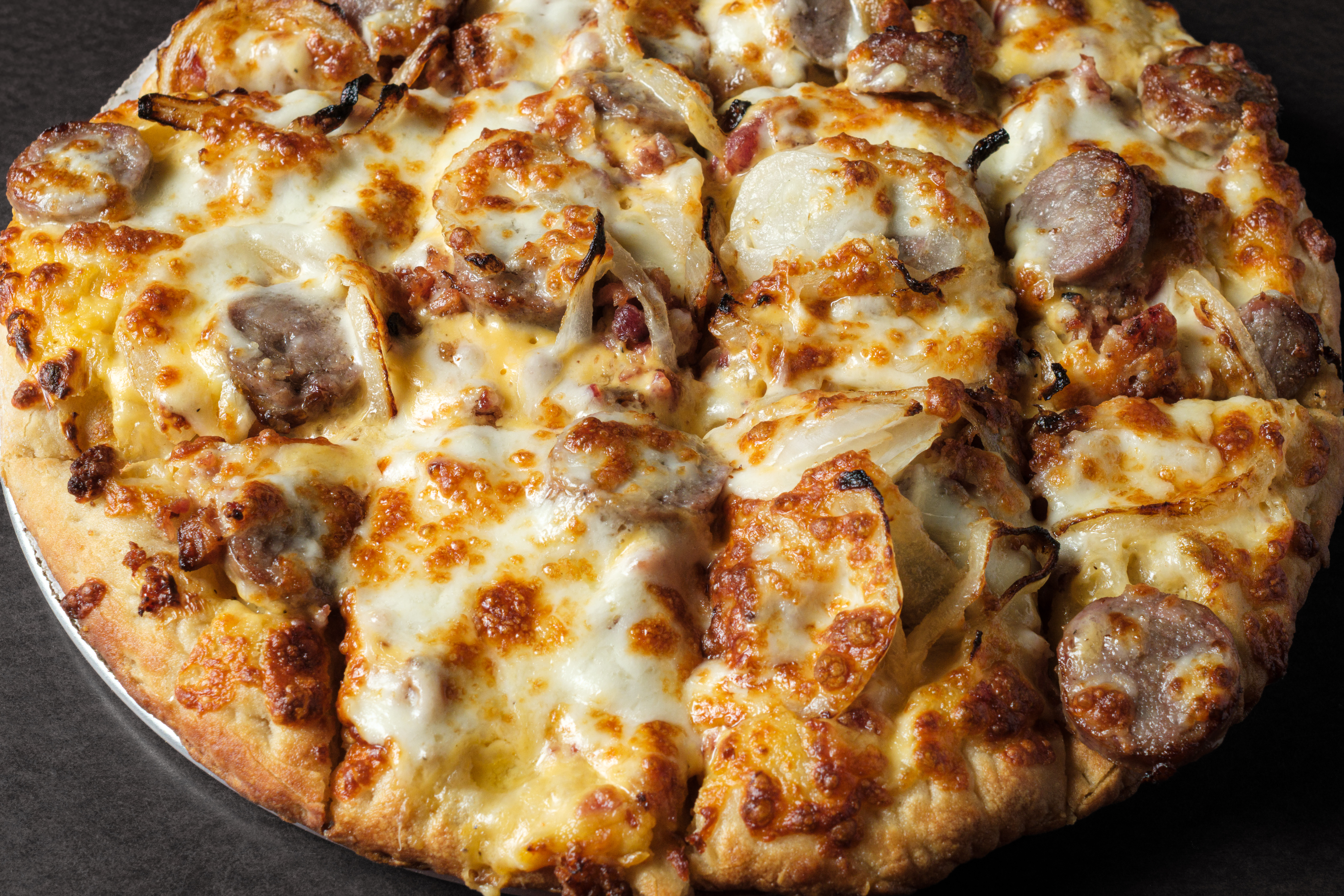 Chicken pizza finished with a ranch drizzle, fresh from the oven