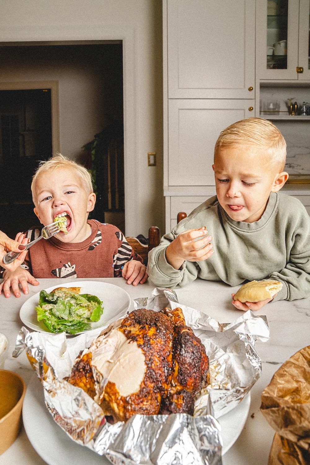Children eating rotisserie chicken at home