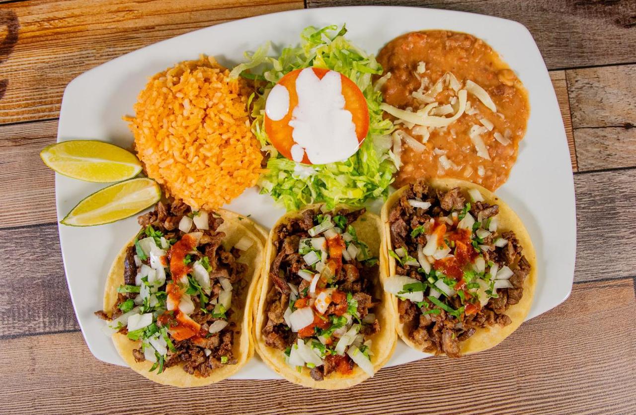 Ground beef tacos with a bowl of charro beans