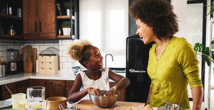 Una mujer cocinando con su hija.