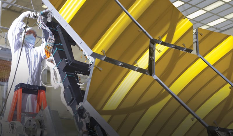 Engineer in clean suit works on the James Webb Space Telescope mirror installation