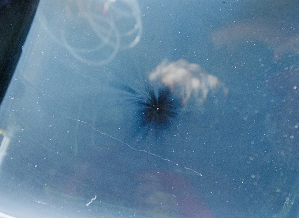 The black mark in this space shuttle window was made by a piece of space debris