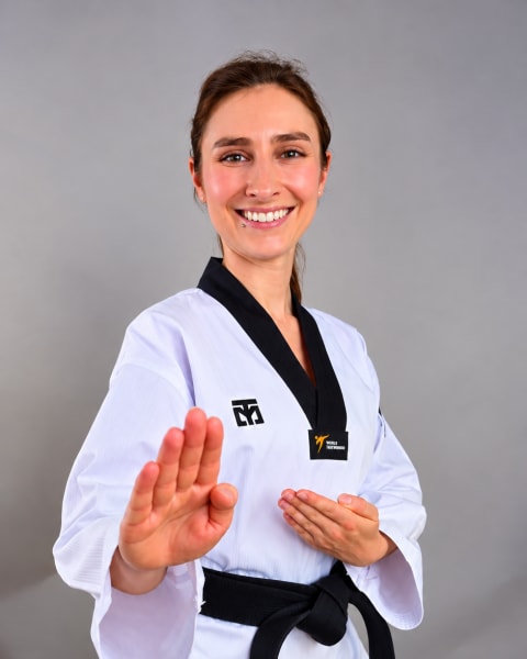 Palina Glebova im Dobok mit schwarzem Gürtel, die Faust in die offene Hand gelegt