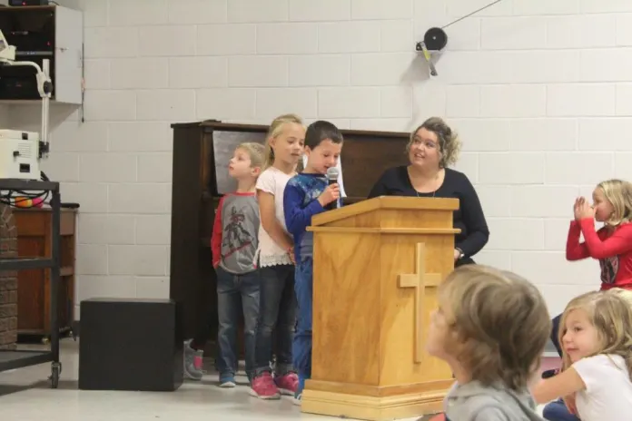 Students are taking turns reading Bible passages during Chapel.