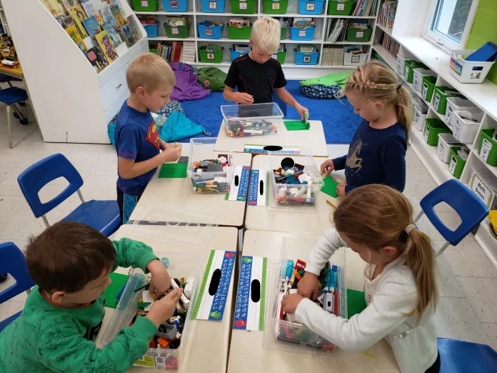 Students are working at their desks with cube blocks for building.