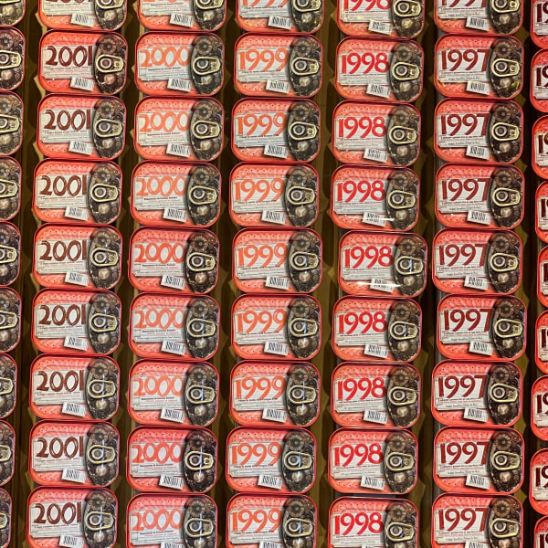 A display of cans labeled with years from 1996 to 2002, arranged in rows.