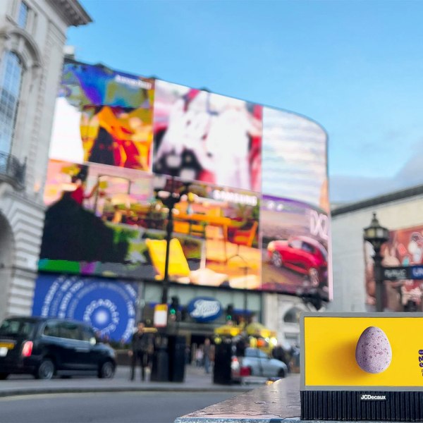 Piccadilly Circus with blurred ads, a Mini Eggs ad in focus, and a London taxi passing by.