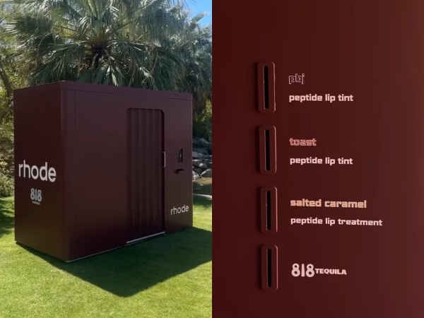 A brown booth with "rhode" branding and lip tint options in a sunny outdoor setting.