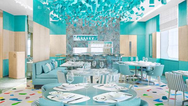 A bright restaurant interior featuring turquoise and modern decor with artistic touches.