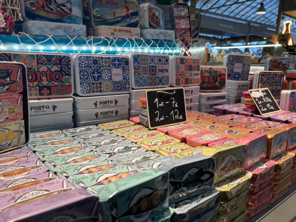 A display of colorful tin cans and promotional signs in a market.