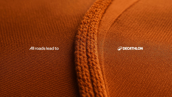 Close-up of textured orange fabric with text: "All roads lead to" and "Decathlon."