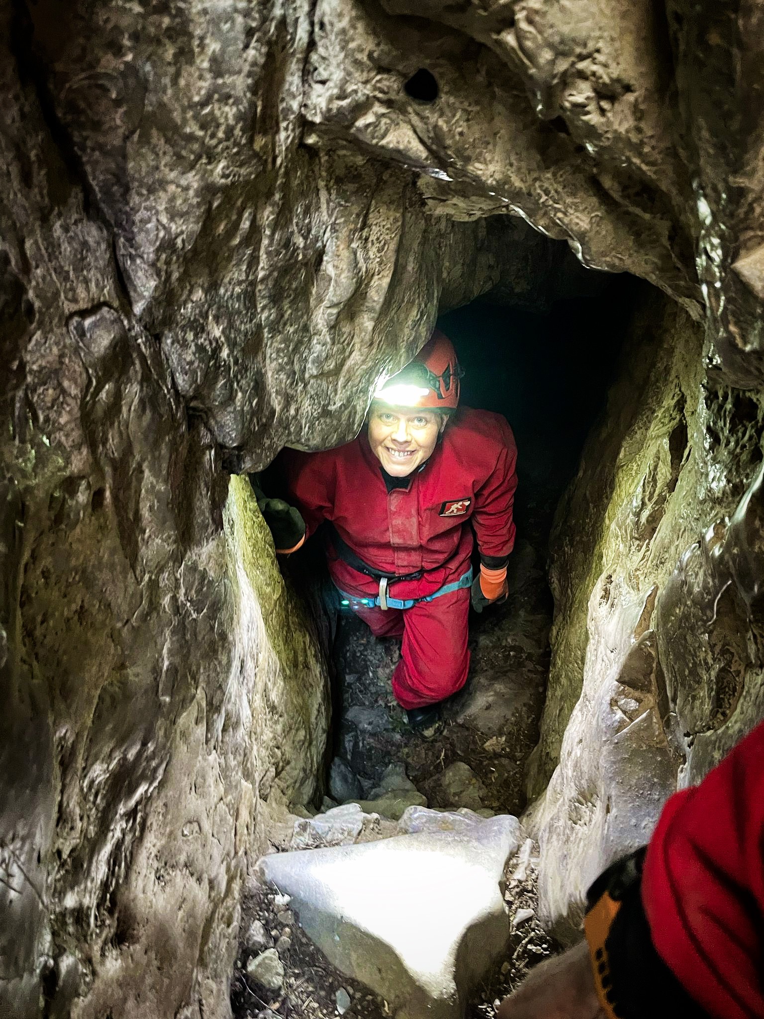Person exploring a cave with headlamp
