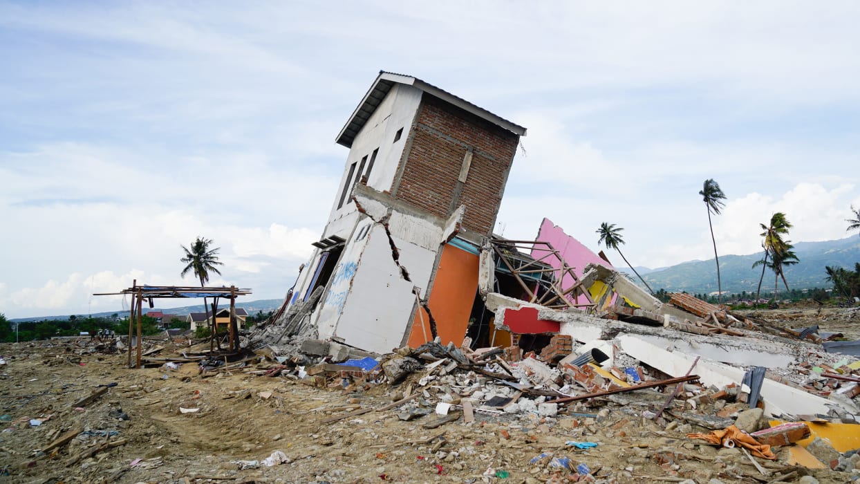 A damaged building surrounded by debris