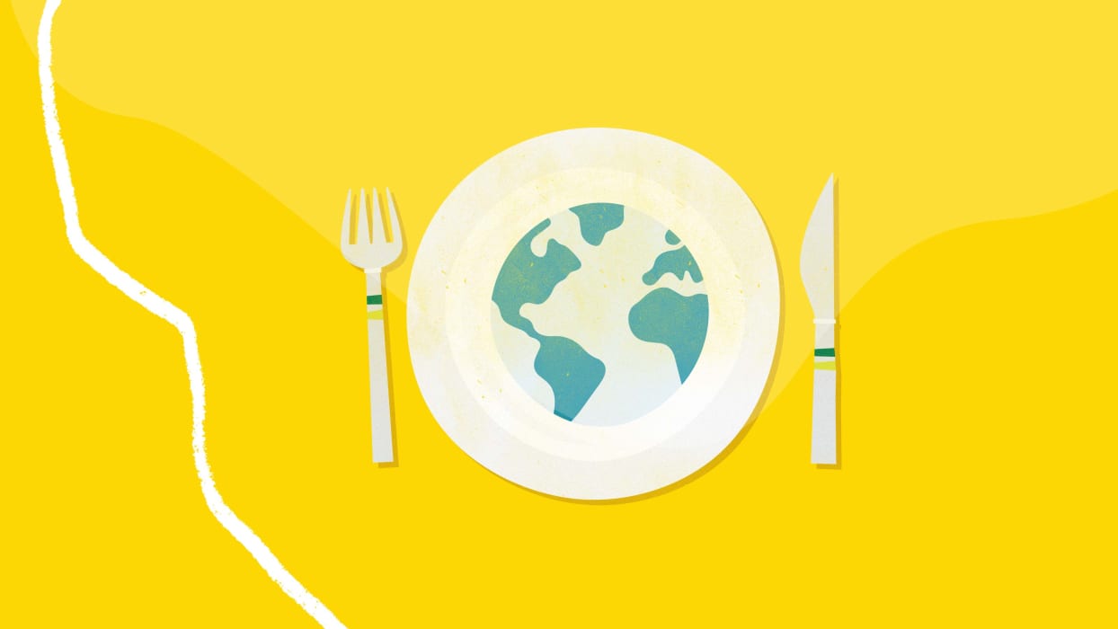 A white dinner plate with a blue and green stylised globe, flanked by a fork and knife with green bands on the handles, all on a textured yellow background.
