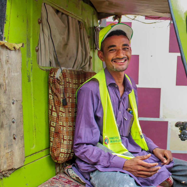 A young man in the drivers seat of a Tuk Tuk in Pakistan