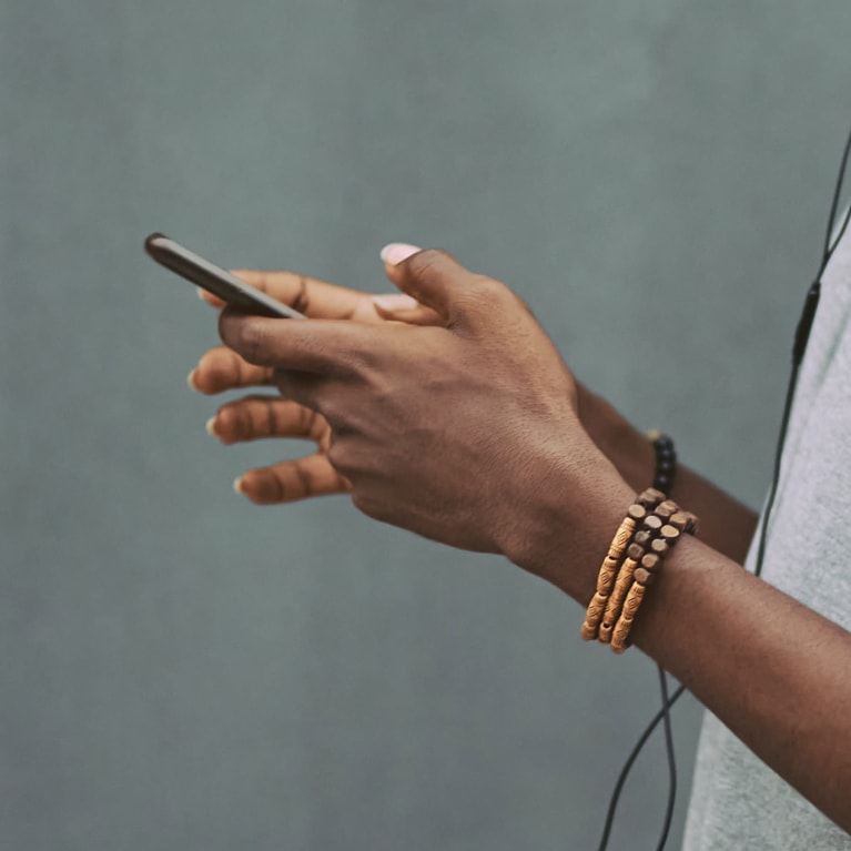 Close-up photo of an African young man holding a mobile phone