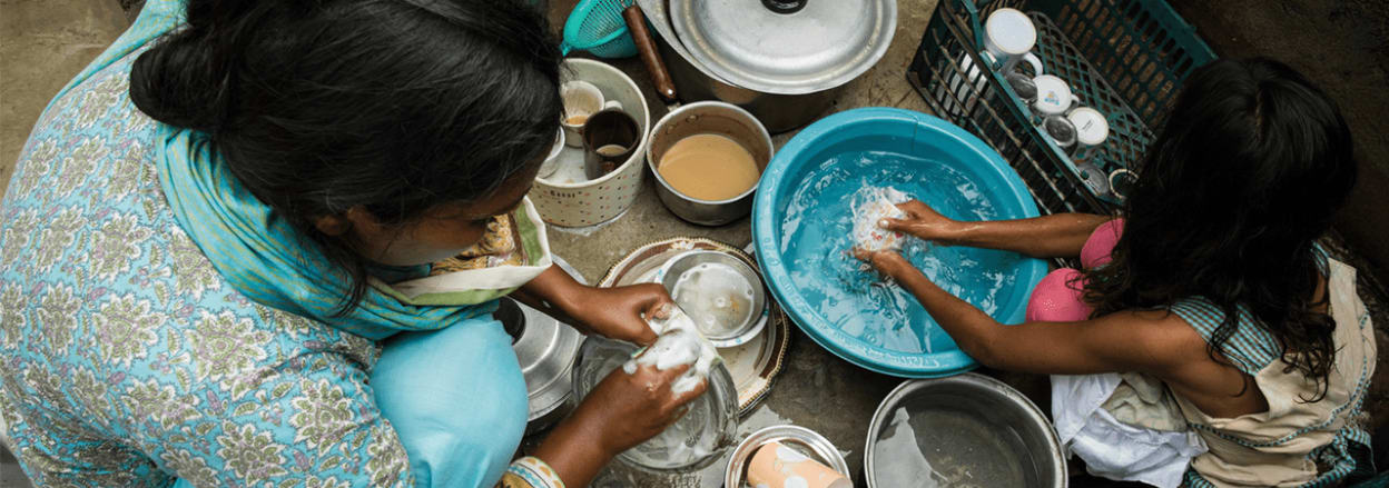 family washing up in bowls on the floor 