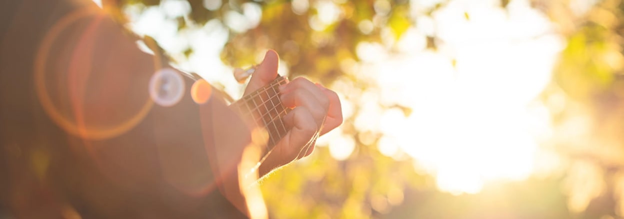 Person playing guitar outside - Clint McCoy / Unsplash