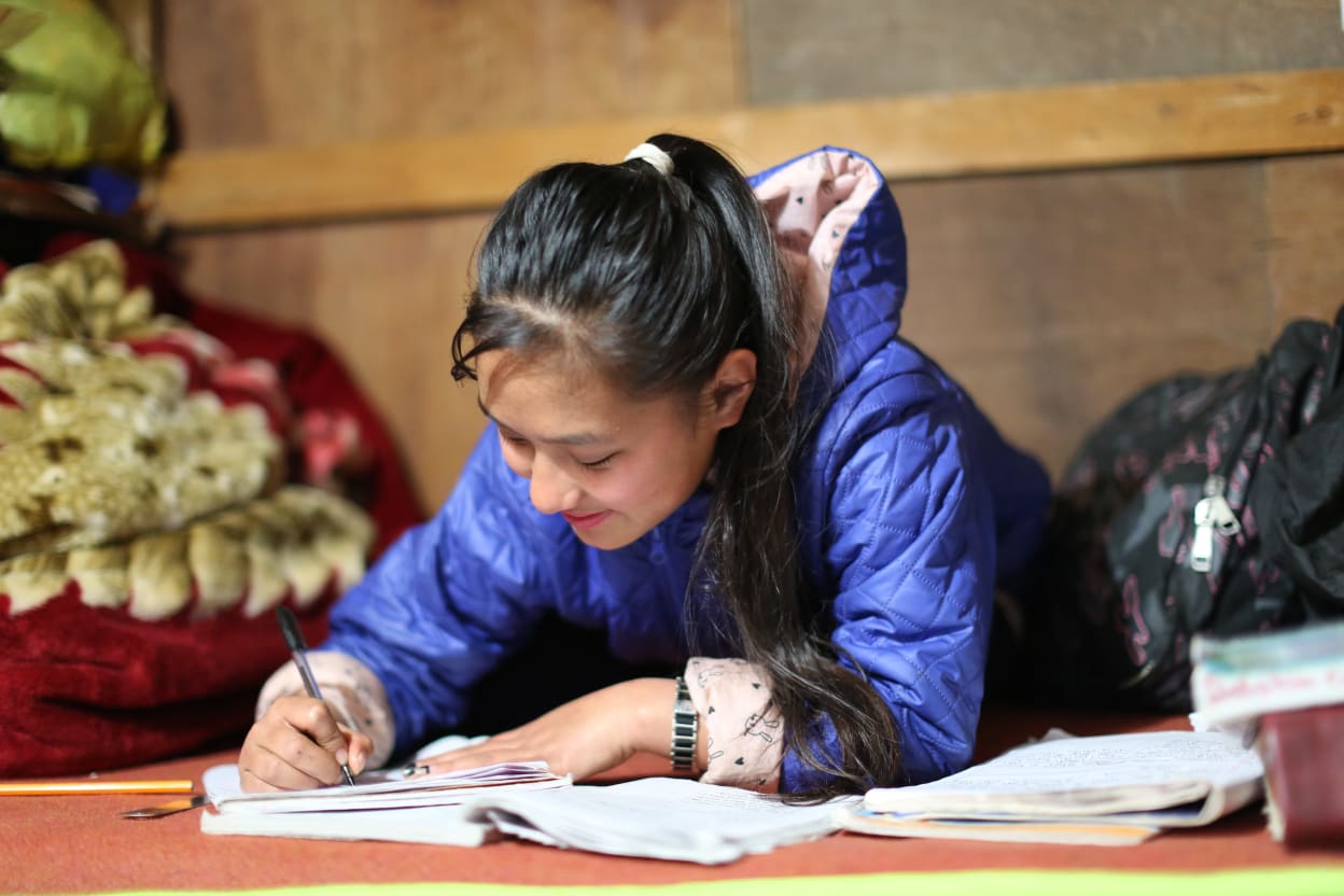 A girl from Nepal studying with electricity provided by hydro-power