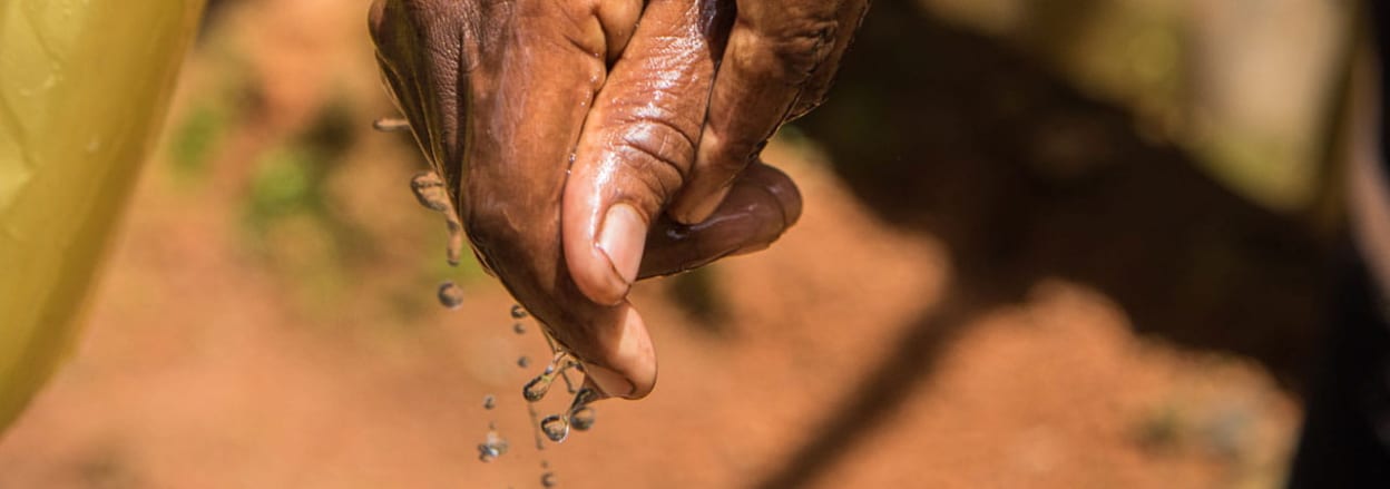 Woman's hand with water running off it.